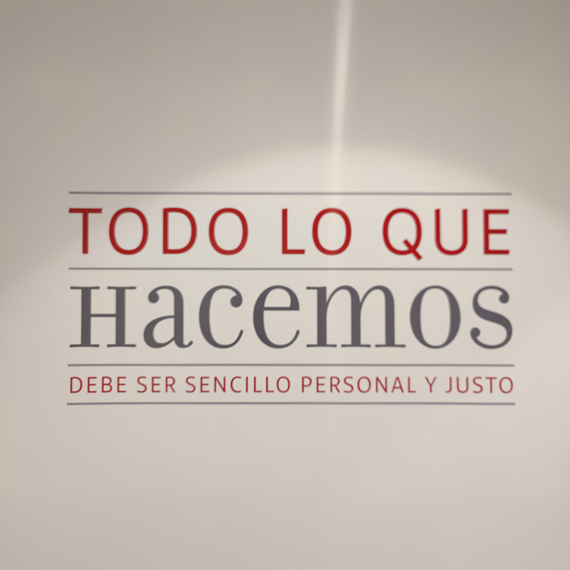 Pared en la que se muestra un vinilo con la frase " todo lo que hacemos debe ser sencillo, personal y justo"